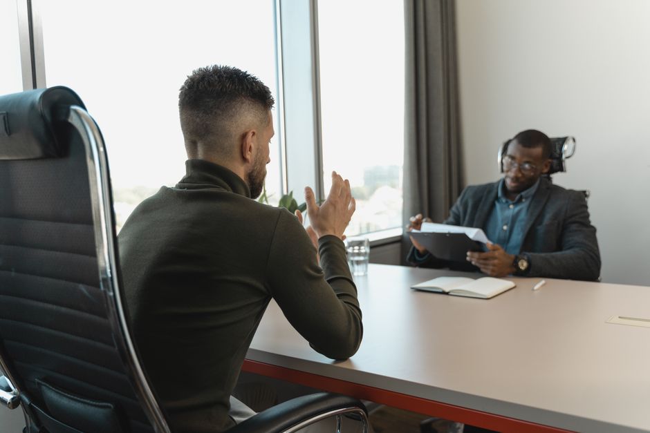 Een kandidaat die zich voorbereidt op een sollicitatiegesprek met notities en een laptop.
